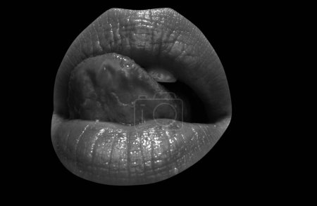Foto de Mujer aislada boca con lengua lamiendo labios con lápiz labial rojo. Lamer la lengua del labio, aislado en negro. Lengua en la boca, primer plano - Imagen libre de derechos