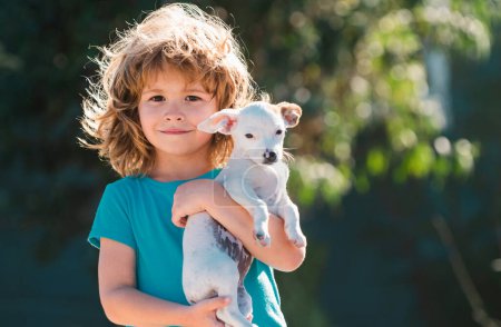 Photo for Cute kid hugging dog. Child and puppy playing outside - Royalty Free Image