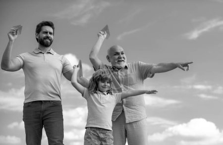 Photo for Fathers day. Kid having fun with toy plane. Men generation family with three different generations ages grandfather father and son. Weekend family play. Journey travel trip concept - Royalty Free Image