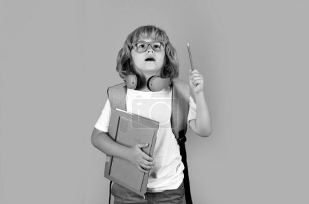 Foto de Retrato del alumno libro sobre fondo de estudio aislado gris. Concepto escolar y educativo. De vuelta a la escuela. Sorprendido emociones asombradas del chico de la escuela - Imagen libre de derechos