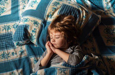 Foto de Lindo niño durmiendo en la cama. Adorables niños pequeños descansan dormidos disfrutan de un buen sueño sano y pacífico o siesta - Imagen libre de derechos