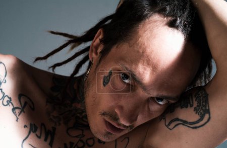 Téléchargez les photos : Portrait d'homme hipster au visage sérieux. Hippie tatoué gars - en image libre de droit