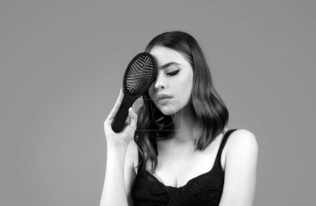 Photo for Smiling woman brushing hair with comb. Beautiful girl with long hair hairbrush - Royalty Free Image