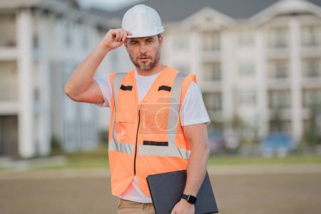 Photo for Engineer with clipboard, building inspection. Builder at building site. Construction manager or engineer in helmet outdoor. Male construction engineer - Royalty Free Image