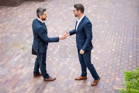 Photo for Successful teamwork. Business people shaking hands. Two businessmen shaking hands outdoors. Shaking hands. Management strategy. Handshake between two businessmen. Teamwork - Royalty Free Image