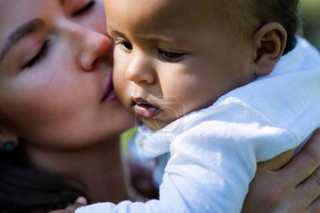 Photo for Mothers kissed baby. Close up portrait of mother kissing multiracial baby. Mother kiss child, macro. Closeup face of Mother with Biracial baby kissing. Tender moms kiss. Mother kiss and love - Royalty Free Image