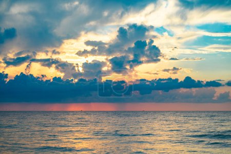 Foto de Calm sea with sunset sky and sun through the clouds over. Sunrise sea on tropical beach. Landscape of beautiful beach. Beautiful sunset at sea. Ocean sunset on sky background with colorful clouds - Imagen libre de derechos
