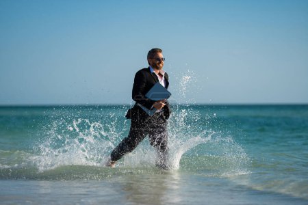 Photo for Excited millennial hispanic business man in suit on sea. Summer vacation, business on sea beach. 40s business man on summer business travel. Dream for summer vacations office workers - Royalty Free Image