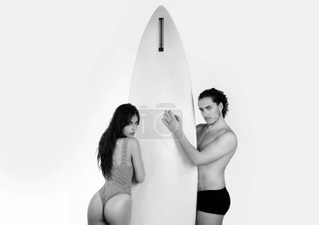 Téléchargez les photos : Couple de surfeurs sexy avec planches de surf isoalté sur blanc. Amitié, mer, vacances d'été, sports nautiques. Amoureux avec planche de surf - en image libre de droit