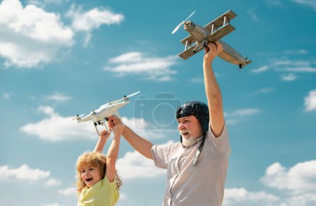Photo for Grandfather and son with plane and quadcopter drone over blue sky and clouds background. Men generation granddad and grandchild. Elderly old relative with child - Royalty Free Image