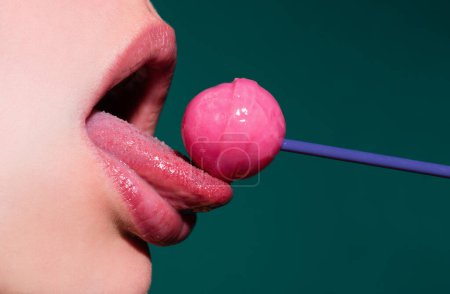 Photo for Licking tongue lips. Lips with candy, sexy sweet dreams. Female mouth licks chupa chups, sucks lollipop - Royalty Free Image