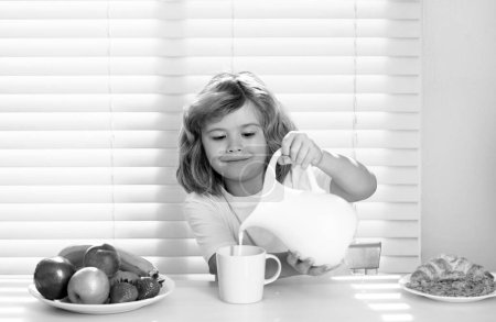 Photo for Little child boy having healthy breakfast. Cute child pouring whole cows milk. Kids nutrition and development. Eating vegetables by child make them healthier - Royalty Free Image
