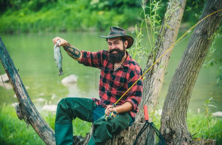 Téléchargez les photos : Un pêcheur a attrapé un poisson. Homme pêche sur la rivière - en image libre de droit