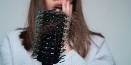 Photo for Closeup hair loss, hair fall in hairbrush, stress problem of woman with a comb - Royalty Free Image