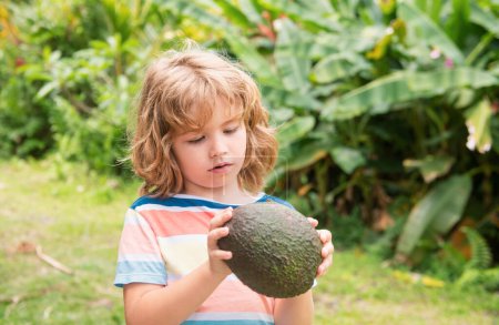 Photo for Cute boy hold avocado, close up portrait on nature background - Royalty Free Image
