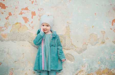 Photo for Autumn fashion. childrens day. little girl in vintage coat on grunge background. Beauty. retro style. copy space. small kid spring clothes. happy childhood. fashion child in autumn coat. - Royalty Free Image