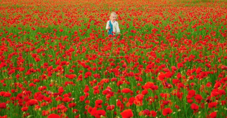 Foto de Chica de primavera. Hermosa niña está usando ropa casual en el campo de las flores de amapola. Fondo de flor de primavera - Imagen libre de derechos
