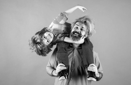 Photo for Happy family. Portrait of happy father giving son piggyback ride on his shoulders. Cute boy with dad in studio - Royalty Free Image