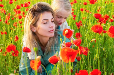 Photo for Woman with child girl in field with red poppies. Mother and daughter are playing in the field of flowering red poppies - Royalty Free Image