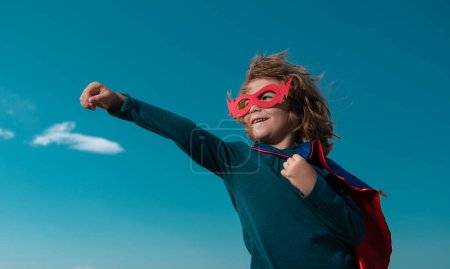 Photo for Portrait of superhero kid against blue sky background. Copy space - Royalty Free Image