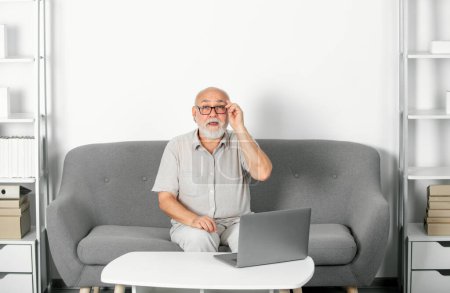 Hombre mayor maduro viendo entrenamiento de negocios, webinar en línea en computadora portátil, trabajo remoto. Trabajadora social senior, psicóloga