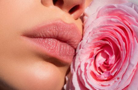 Photo for Close up sexy woman natural lips and beautiful red rose. Lips with lipstick closeup. Beautiful woman lips with rose - Royalty Free Image