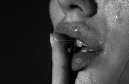 Foto de Miel goteando boca con labios sexys, primer plano. Cierra los labios sensuales de mujer con lápiz labial rojo. Labios apasionados - Imagen libre de derechos
