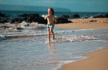 Téléchargez les photos : Le gamin court sur la plage. Joyeux enfant courir en mer pendant les vacances d'été. Voyage et aventure sur mer ou océan - en image libre de droit