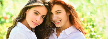 Foto de Banner de primavera con mujeres novias al aire libre. Dos mujeres bonitas felices posando juntas mientras miran a la cámara sobre un fondo verde - Imagen libre de derechos