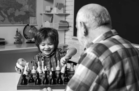 Photo for Grandfather father and child grandson playing chess, learning at home - Royalty Free Image
