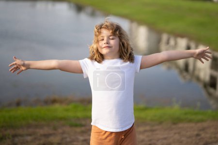 Photo for Kid with arms up enjoying freedom in nature. Child open arms enjoying freedom. Kid raising arms up feelings of freedom in nature. Kid closed eyes in summer nature. Kids summer holiday vacation - Royalty Free Image