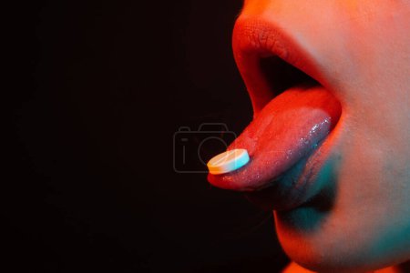 Photo for Pills for sex. Woman taking pills, closeup. Take medicine. Female tongue with tablet pills. Cropped photo with red lips holding pill in mouth. Impotence. Potency Pill. Medicine Sexual Health Problems - Royalty Free Image