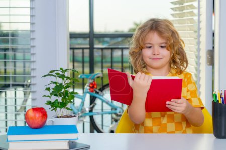 Photo for School kid reading book. School child student learning at home, study english language. Elementary school child doing homework in her room. Portrait of funny pupil learning - Royalty Free Image