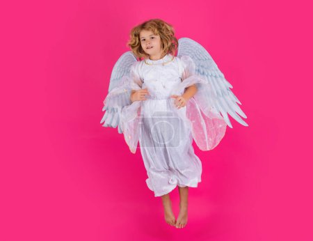 Foto de Salto de angelito, niños saltando, cuerpo entero. El angelito vuela. Retrato de niño lindo con alas de ángel aislado en el fondo del estudio. angelito, día de San Valentín. Niños angelicales - Imagen libre de derechos