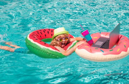 Photo for Happy little boy learning online computer laptop. Child relax and rest on colorful inflatable ring using computer in swimming pool. Summer business and technology - Royalty Free Image