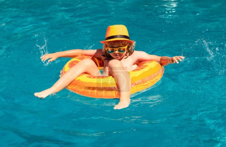 Téléchargez les photos : Petit garçon enfant dans la piscine avec anneau de jouet gonflable. Les enfants nagent en vacances d'été. Nager pour enfant sur flotteur. Plage mer et eau plaisir - en image libre de droit
