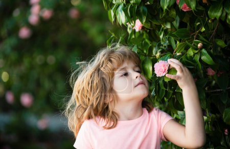 Photo for Cute little child picking flowers in blooming summer garden. Spring child face. Happy little child with flowers on the grass in a summer. Cute little child on the meadow in backyard - Royalty Free Image
