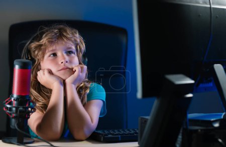 Foto de Niño con PC por la noche. Escuela, estudio, concepto de aprendizaje en línea. El abuso y la adicción de los niños de gadgets - Imagen libre de derechos
