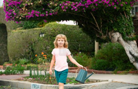 Foto de Lindo niño regando plantas en el jardín - Imagen libre de derechos