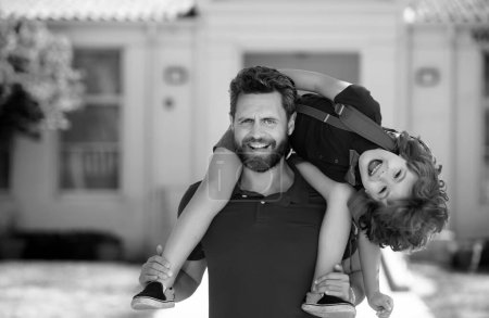 Photo for Father giving son piggyback ride after come back from school. School, family, education and outdoor concept. Funny kids face - Royalty Free Image