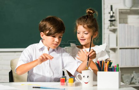 Foto de Niños hermano y hermana dibujando lindo dibujo utilizando lápices de colores en la escuela o jardín de infantes. Aprendizaje infantil, habilidades artísticas para niños - Imagen libre de derechos