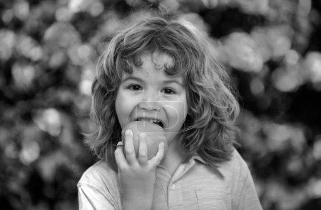 Photo for Little cute child eating green apple. Portrait of kid eating and biting an apple. Enjoy eating moment. Healthy food and kid concept - Royalty Free Image