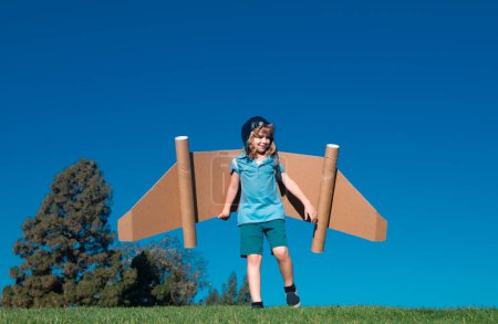Photo for Happy child playing with toy jetpack. Kid pilot having fun on green grass outdoor. Success, kids innovation and leader concept - Royalty Free Image