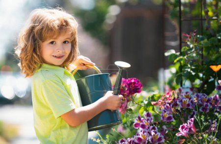 Foto de Plantas de riego para niños activas en el patio trasero. Niño ayudando a arents a cultivar hierbas y flores en el jardín - Imagen libre de derechos