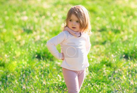 Foto de Niña caminando en hierba verde. Niño divirtiéndose en picnic familiar en el jardín de verano - Imagen libre de derechos
