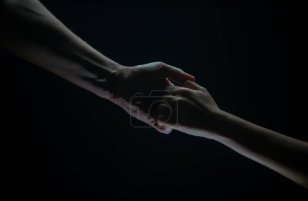 Photo for Helping hand outstretched, arm on salvation. Close up strong hand. Two hands, helping arm of a friend, teamwork. Rescue, power, helping gesture or hands. Black background - Royalty Free Image