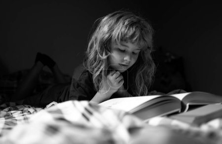 Téléchargez les photos : Un gamin lisant des livres. Rêver enfant lire des histoires au coucher, conte de fées ou conte de fées - en image libre de droit