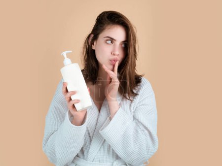 Foto de Mujer con botella de bálsamo, champú y acondicionador. Producto de belleza - Imagen libre de derechos