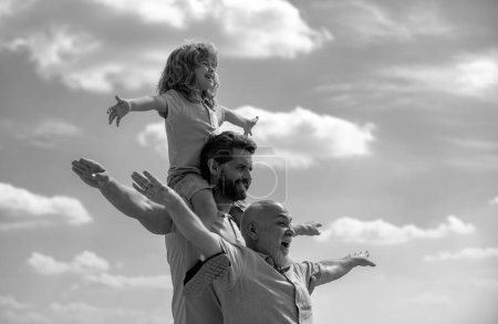 Active family leisure with kids. Boy son with father and grandfather Raising hands or open arms flying on summer sky background. Start, creativity startup concept