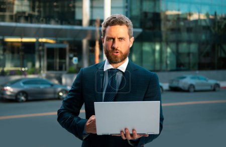 Téléchargez les photos : Homme d'affaires senior travaillant sur ordinateur portable près du bureau extérieur - en image libre de droit